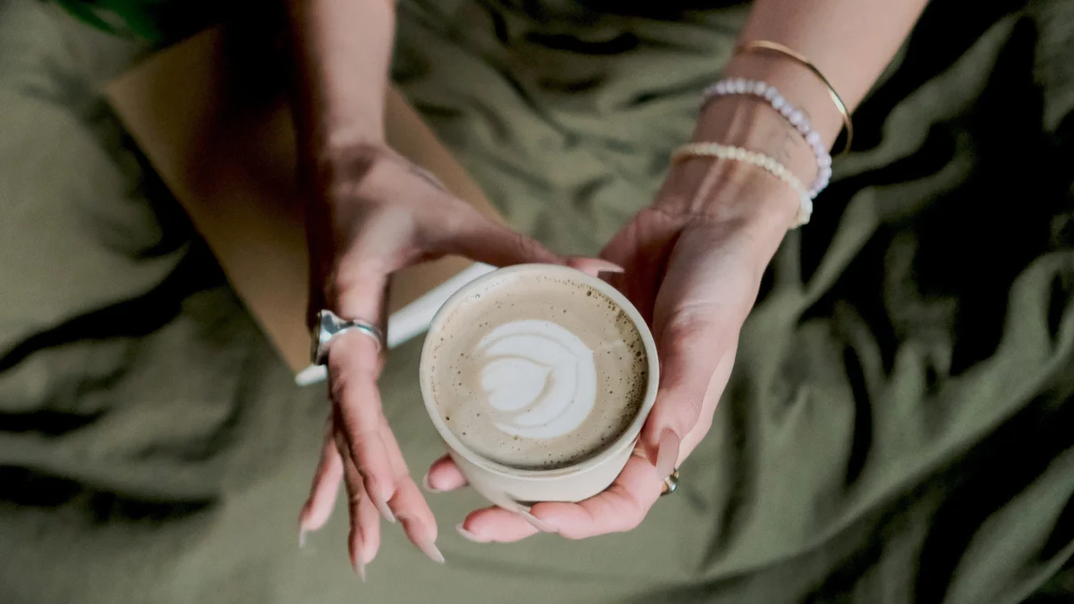 a cup of hojicha held in two hands