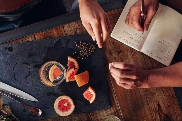 spices, citrus and a notebook on a dark board